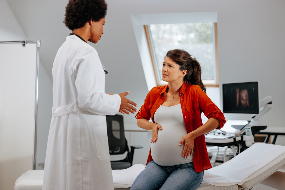 Pregnant woman talking to her obgyn about bleeding.