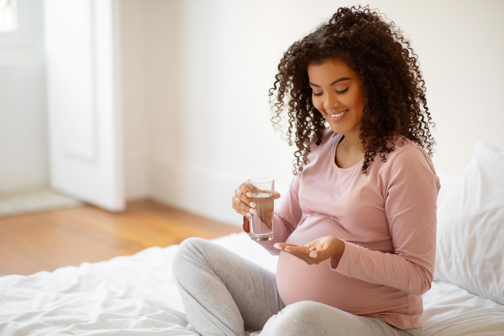 Pregnant woman taking medication.