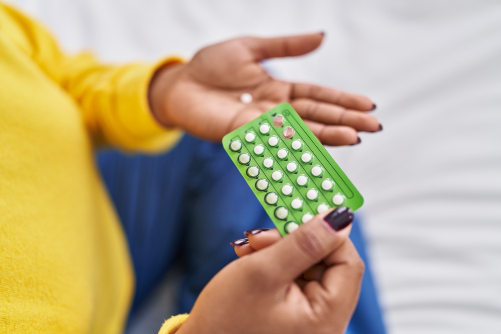 woman holding birth control pills.